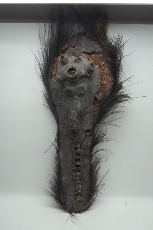 Antique African Mask: Antique African zoomorphic mask having oblong shape. With feathered border and cowry shell detailing. Height: 38.5 inches