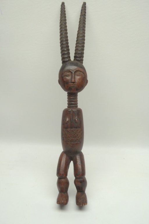 Antique Carved Anthropomorphic African Figure: Carved African female figure having stylized gazelle antlers. Also having banded neck and carved design to stomach. Size: 13" H