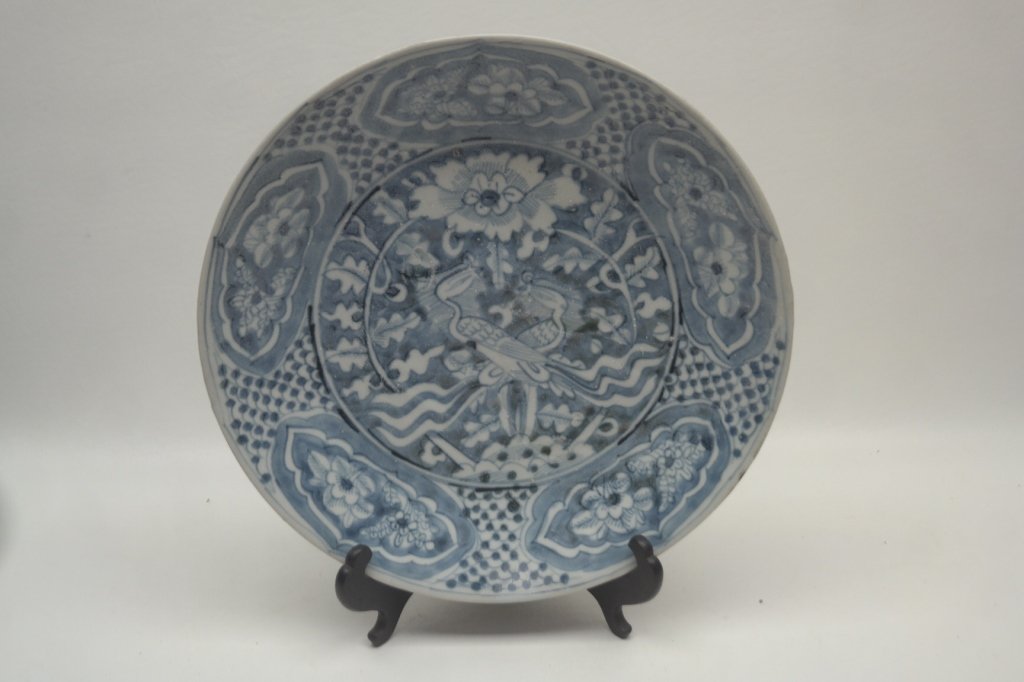 Ming Dynasty Blue and White Porcelain Plate: Antique Ming dynasty swatow porcelain plate. Having blue and white decorations in the double phoenix design. Also with floral motifs. Reverse of plate having barnacles to base.