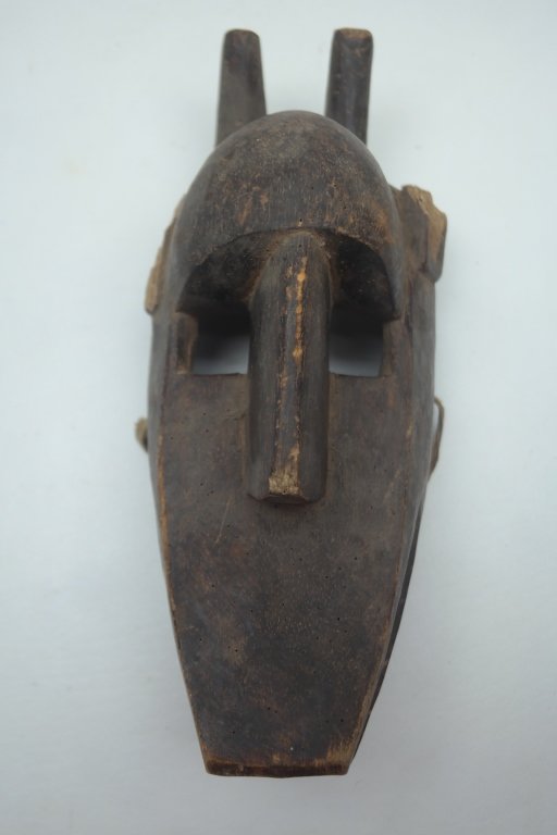Antique African Mask: Antique carved African mask in wood construction. Having carved horns and squared eyes. With evidence of having carved ears.