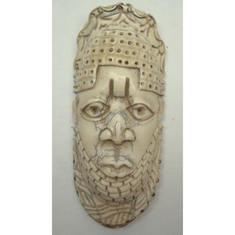 Antique Carved African Ivory Sculpture of Face: Antique carved African Ivory in form of stylized face depicted wearing a headdress. Size: H: 7 in