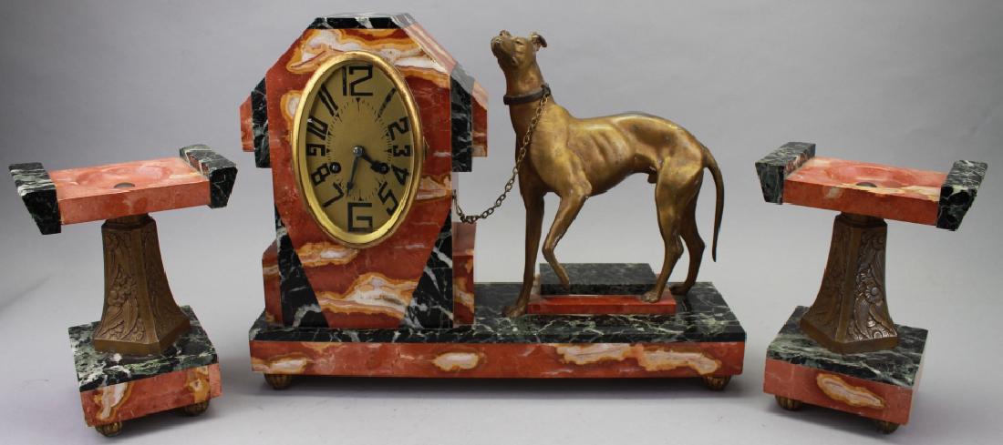 Figural Art Deco Clock/Garniture Set: Figural Art Deco Clock/Garniture Set. With Bronze Whippet figure chained to clock. Marble base. Size: 12.25 x 16 in. (clock) 8 x 6 in. (compotes). All clocks/lamps are sold for display purposes only.