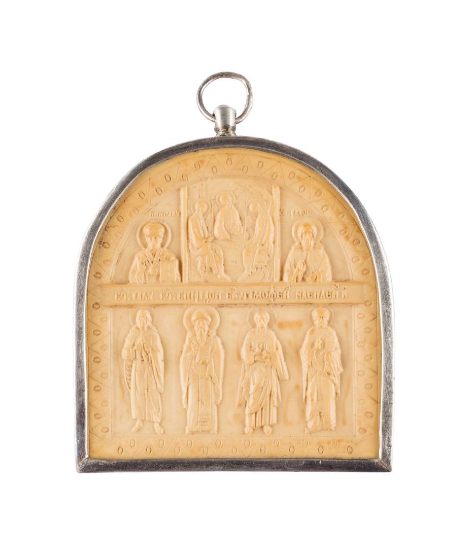 A CARVED BONE PECTORAL ICON SHOWING THE OLD TESTAMENT: A CARVED BONE PECTORAL ICON SHOWING THE OLD TESTAMENT TRINITY AND SELECTED SAINTS 2nd half 20th century Carved in relief. Metal-mounted. 8.4 x 7.4 cm. BRUSTIKONE MIT DER ALTTESTAMENTLICHEN DREIFALTIGK