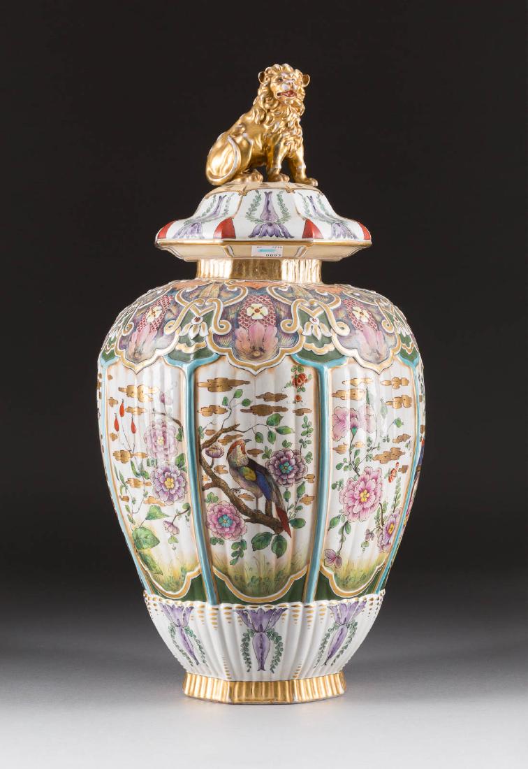 GROSSE RELIEFIERTE DECKELVASE MIT DEKOR IM ASIATISCHEM: GROSSE RELIEFIERTE DECKELVASE MIT DEKOR IM ASIATISCHEM STIL Deutsch, Aelteste Volkstedter Porzellanfabrik, 1915-1936 Porzellan, polychrome Malerei, Goldstaffage. H. 55 cm. Unterglasurblaues 'N' mit 'E