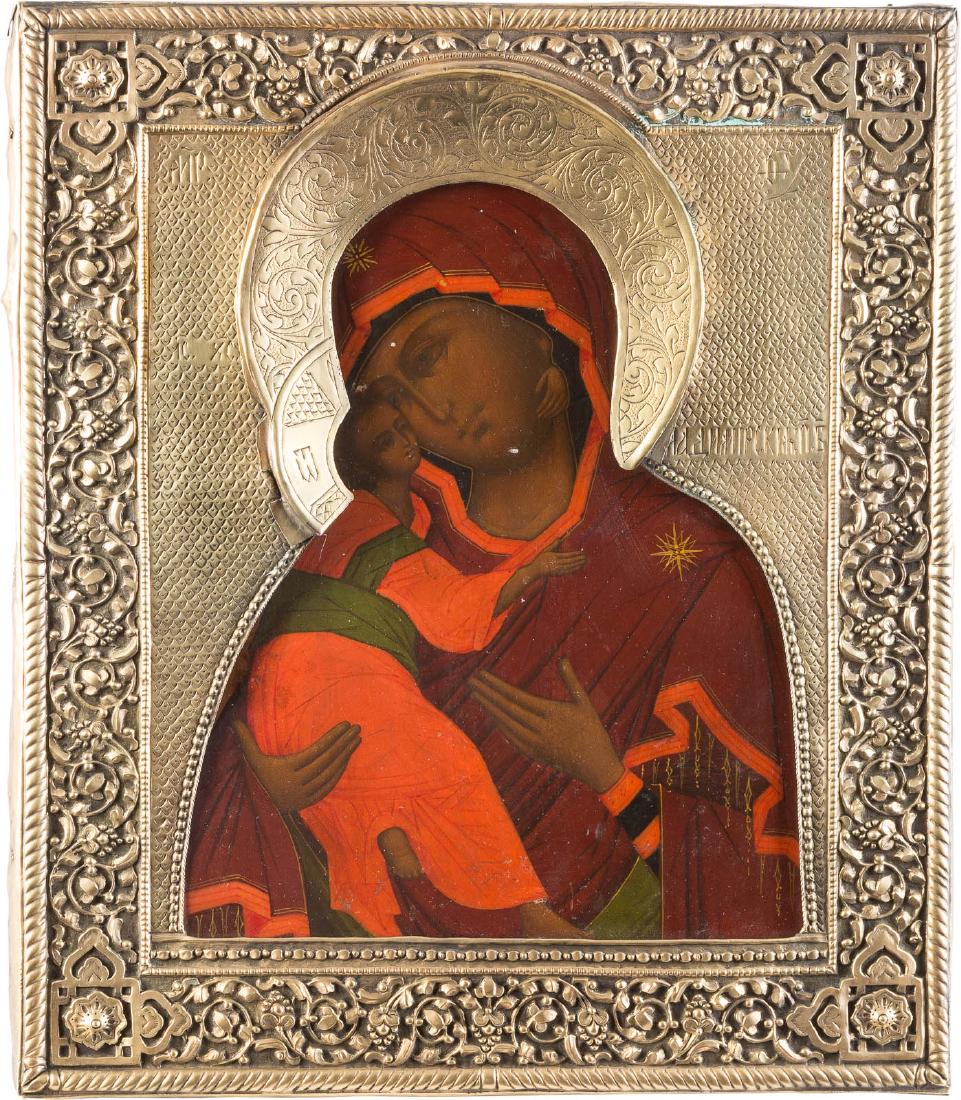 AN ICON SHOWING THE VLADIMIRSKAYA MOTHER OF GOD WITH: AN ICON SHOWING THE VLADIMIRSKAYA MOTHER OF GOD WITH RIZA Russian, circa 1900 Tempera on wood panel with velvet backing. Overlaid with a chased and embossed brass riza. Minimally restored. 31.2 x 26.8