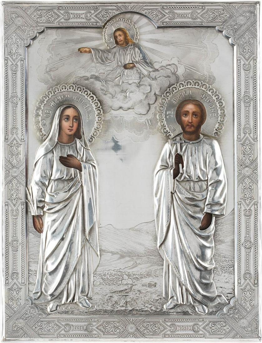 A LARGE ICON SHOWING STS. NATALIYA AND ADRIAN WITH A: A LARGE ICON SHOWING STS. NATALIYA AND ADRIAN WITH A SILVER OKLAD Russian, circa 1885 (icon), Russian, Moscow, Antip Ivanovitch Kuzmitchev, 1885 (oklad) Oil on wood panel. Overlaid with a chased and f