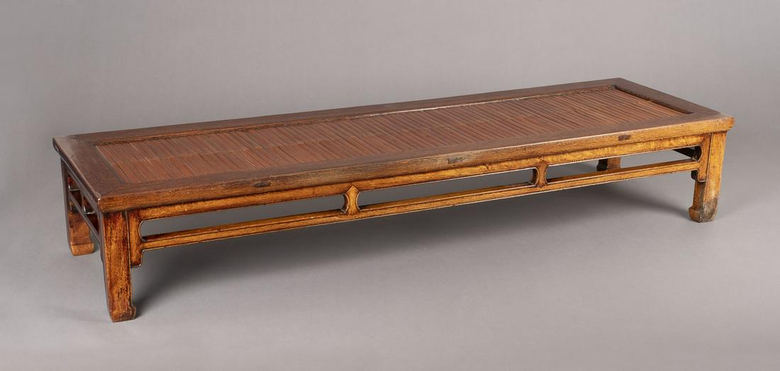 EINE SITZBANK AUS HOLZ: A WOODEN BENCH China, probably 20th century Wood/Bamboo. 55x186.5x32.5 cm. The bench is laid with bamboo on the top. With traces of use, small damages and scratches.EINE SITZBANK AUS HOLZ China, wohl 