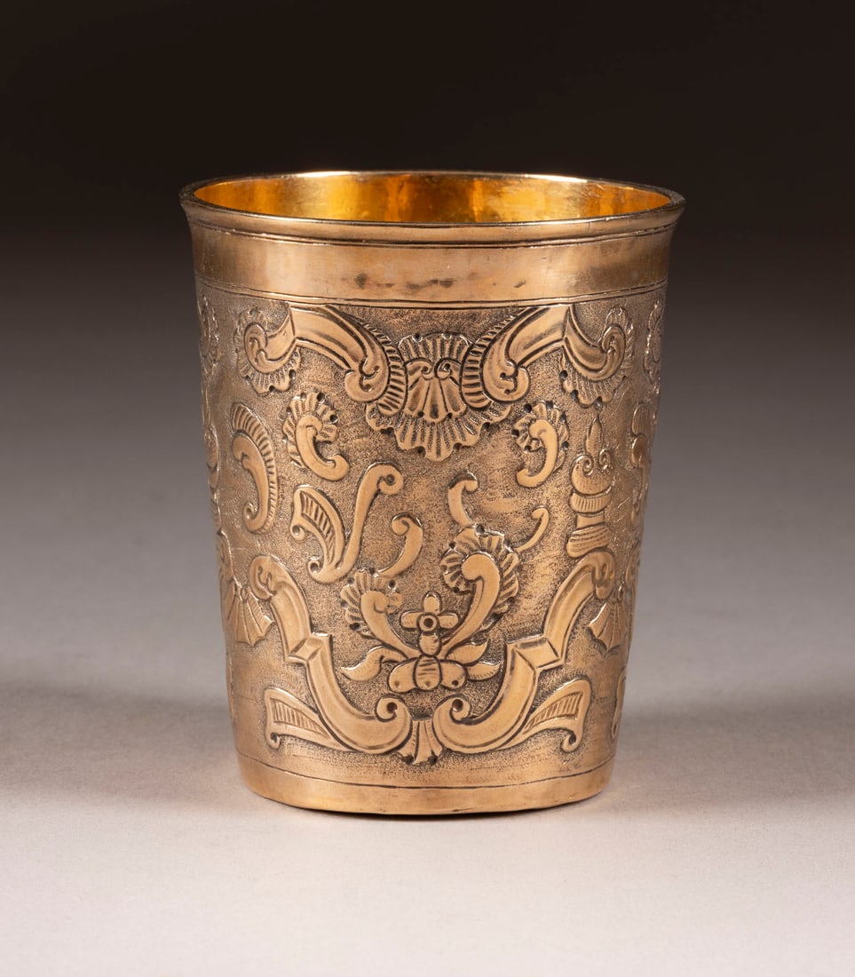A SILVER-GILT BEAKER: A SILVER-GILT BEAKER Russian, Moscow, 1750 Of tapering form. The body chased with rocailles on stippled ground. Marked under base with city hallmark, assayer's mark and master's mark. 8.6 cm high, 88