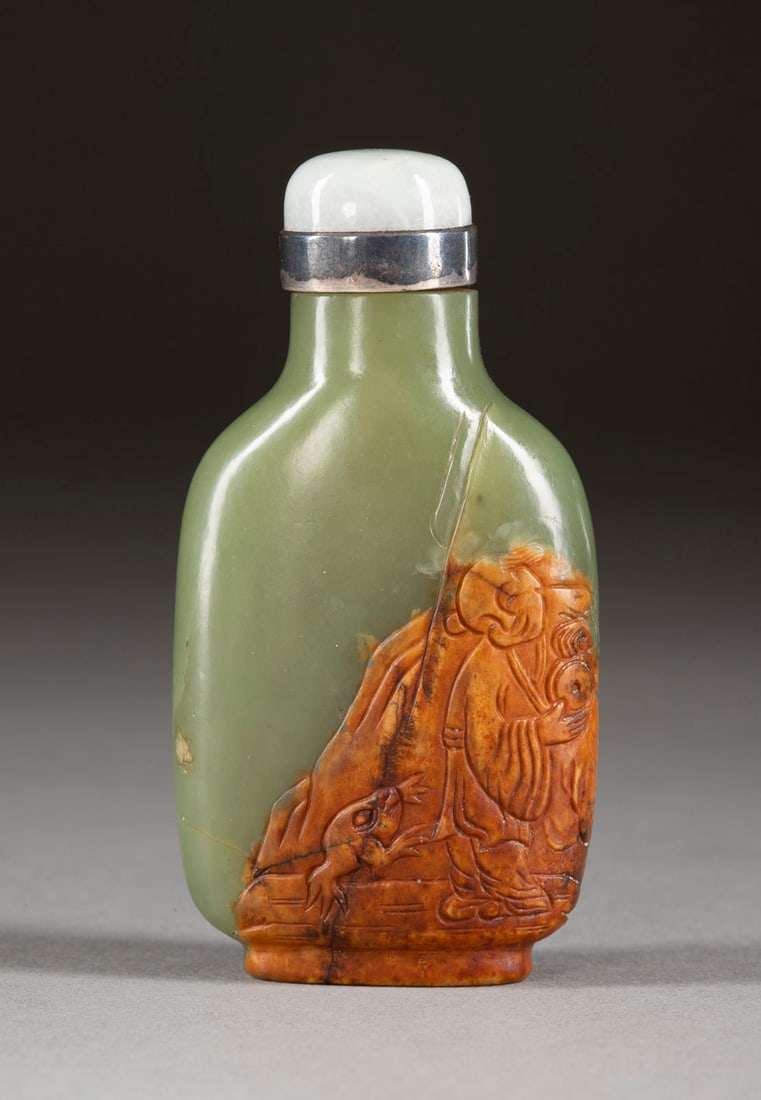 A CARVED RUSSET-BROWN AND SPINACH-GREEN JADE SNUFF BOTTLE: A CARVED RUSSET-BROWN AND SPINACH-GREEN JADE SNUFF BOTTLE China, 18th/19th century Jade. H. 7.8 cm. The bottle is carved on one side in low-relief utilizing the russet-brown skin to depict Liu Hai and