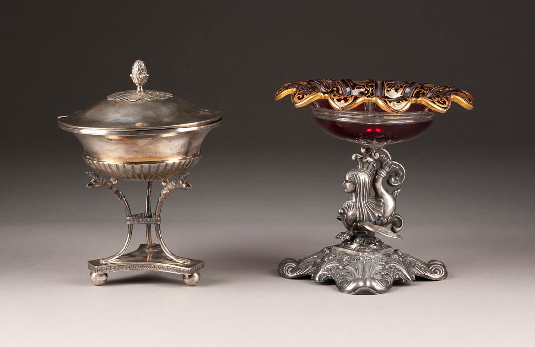 KONVOLUT ZWEIER TAFELAUFSÄTZE: KONVOLUT ZWEIER TAFELAUFSÄTZE Deutsch/Schweden, um 1830 Silber, farbloses Glas mit rotem Überfang und Schliffdekor, teils mit Goldbemalung. H. 18,5 bzw. 21 cm, D. 20 bzw. 15 cm. Der Biedermeier Tafe