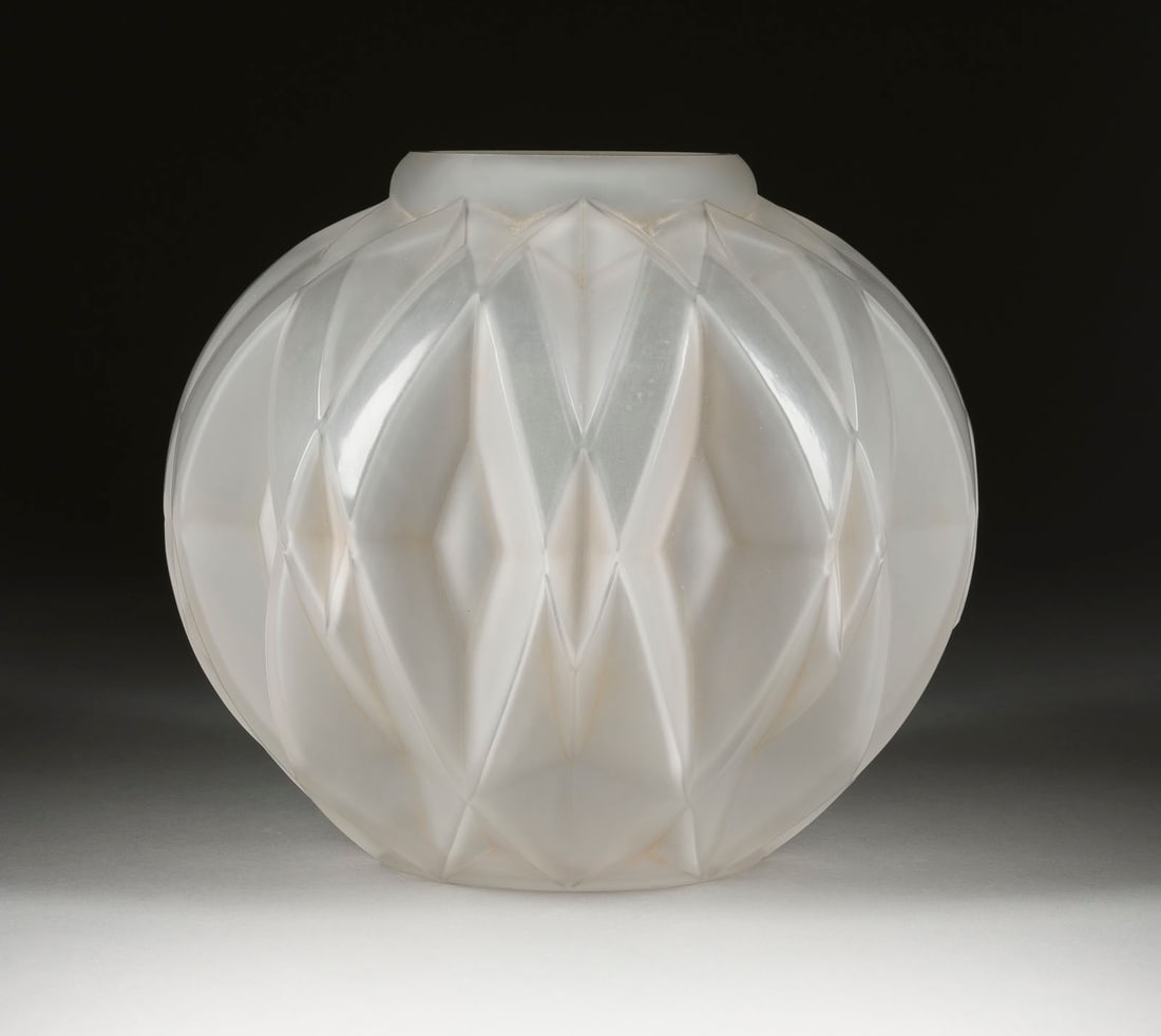 ANDRE HUNEBELLE ART-DECO-VASE: ANDRE HUNEBELLE 1896 - 1985 ART-DECO-VASE Frankreich, Paris, 1930er Farbloses Pressglas, satiniert. H. 20 cm. Auf Wandung bez. 'A.Hunebelle'. Kugelige Form. Umlaufender geometrische Reliefdekor. An Mu