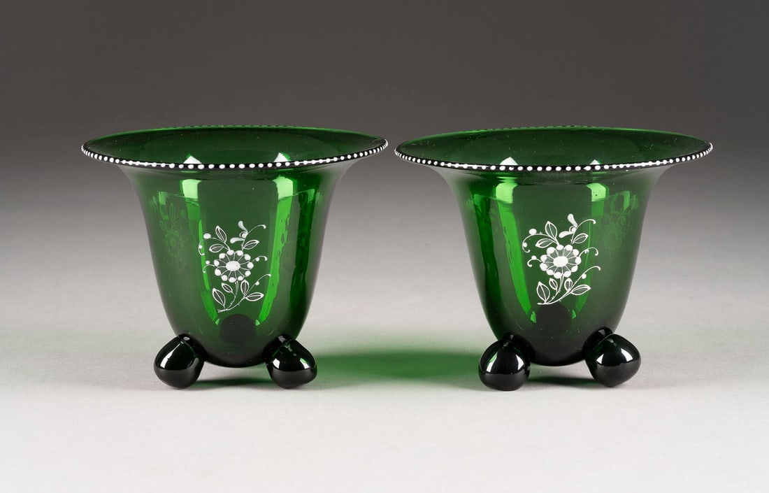 PAAR KLEINE FUSSSCHALEN: PAAR KLEINE FUSSSCHALEN Boehmen, Klostermuehle, Loetz Witwe, Huettenvariante nach Michael Powolny (Entwurf), um 1915 Gruenes Glas, weisse Emailmalerei. H. 10,5 cm, D. 13 cm. Auf drei Glaskugeln glocke