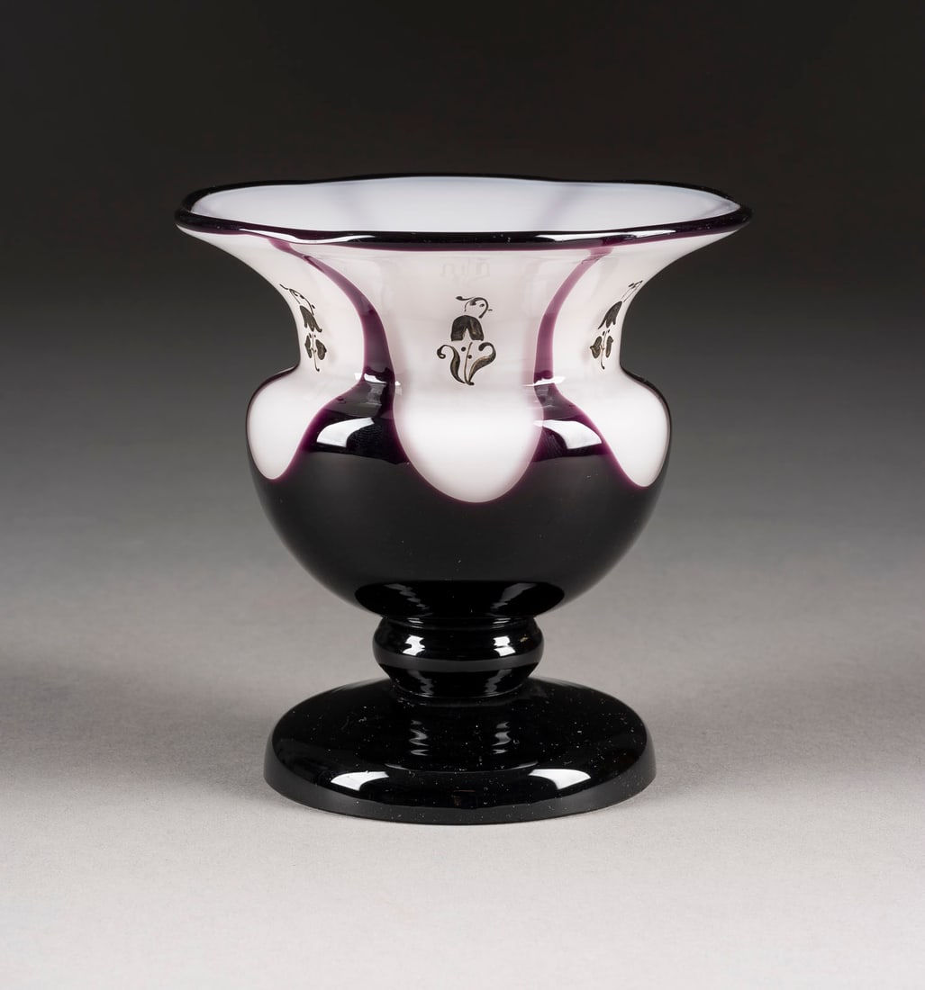 KLEINE FUSSVASE: KLEINE FUSSVASE Boehmen, Klostermuehle, Loetz Witwe, Hans Bolek (Entwurf), um 1918/1921 Opalweisses und dunkelviolettes Glas, dezente Schwarzlotmalerei. H. 11,7 cm, D. 11,6 cm. Ausfuehrung 177.