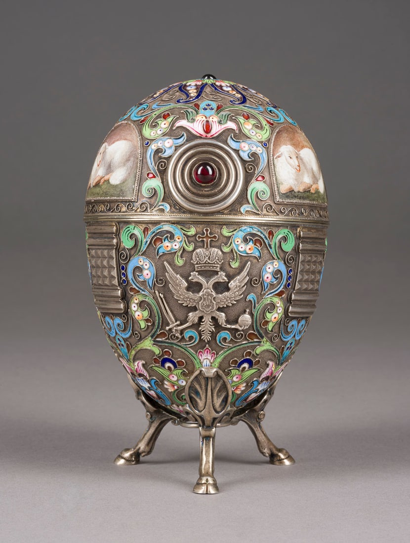 CLOISONNÉ-EMAIL-EI MIT SCHAFEN: A LARGE SILVER AND CLOISONNÉ ENAMEL EGG 2nd half 20th century The body decorated with sheep in plein enamel surrounded by scrolling foliage in shaded enamel on a stippled ground. Gilt interior. Beari