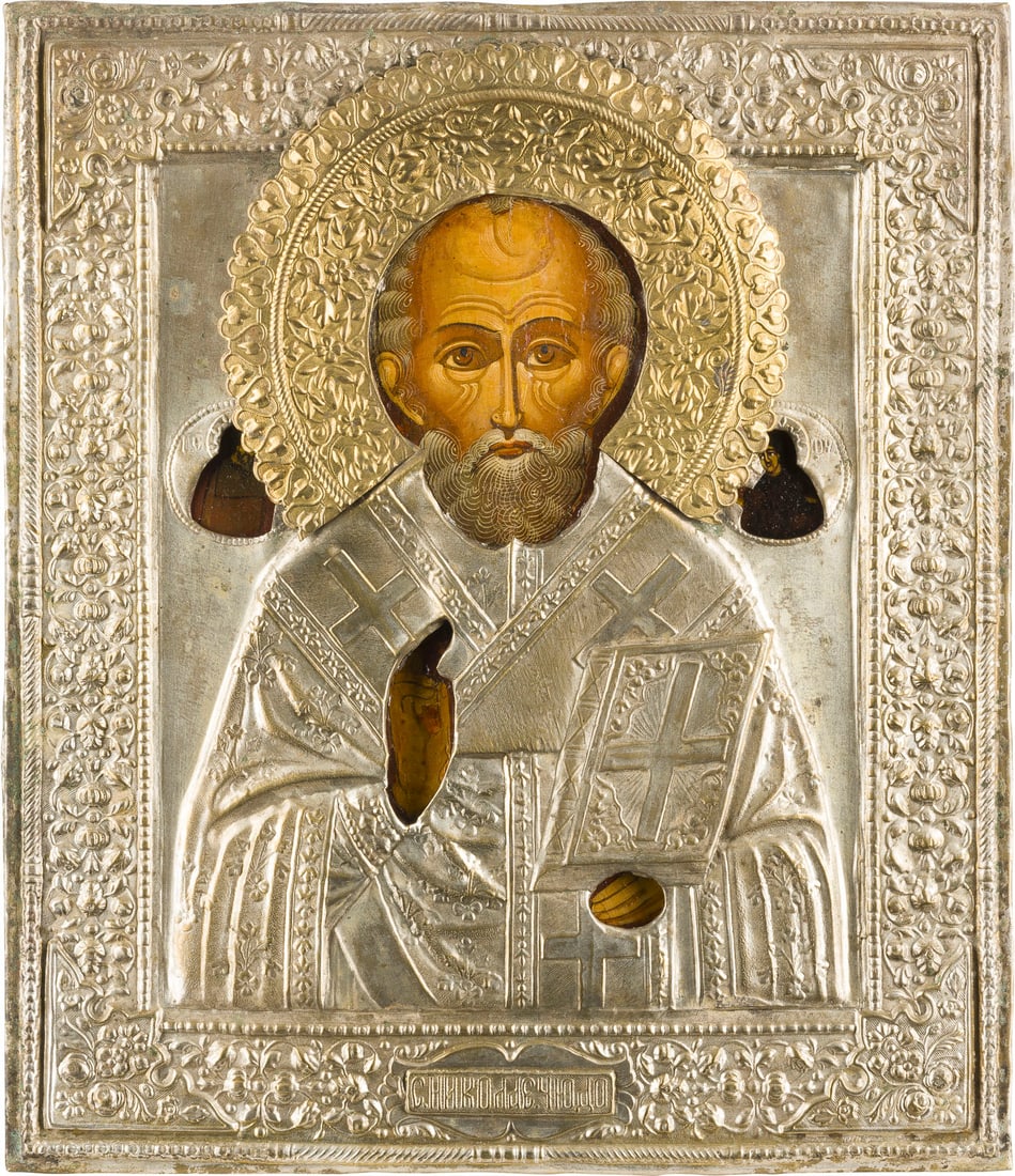 IKONE MIT DEM HEILIGEN NIKOLAUS VON MYRA MIT OKLAD: AN ICON SHOWING ST. NICHOLAS OF MYRA WITH OKLAD Russian, 2nd half 19th century Tempera on wood panel. Overlaid with a chased metal oklad. Vertical cracks restored. 30.7 x 26.7 cm.IKONE MIT DEM HEILIGE