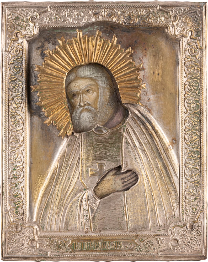 KLEINE IKONE MIT DEM HEILIGEN SERAFIM VON SAROW MIT OKLAD: A SMALL ICON SHOWING ST. SERAPHIM OF SAROV WITH OKLAD Russian, after 1903 Tempera on wood panel. Overlaid with a chased metal oklad. Partially restored. 23 x 18 cm.KLEINE IKONE MIT DEM HEILIGEN SERAFI