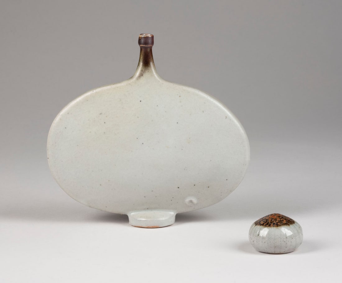 BRUNO & INGEBORG ASSHOFF - FLASCHE UND PAPERWEIGHT: BRUNO & INGEBORG ASSHOFF 1914 - 2003 und 1919 - 1998 BOTTLE AND PAPERWEIGHT after 1967 Stoneware, thrown, mounted, light-grey glaze, partly reddish-brown and copper-red crystals, bottle w. craquelure.