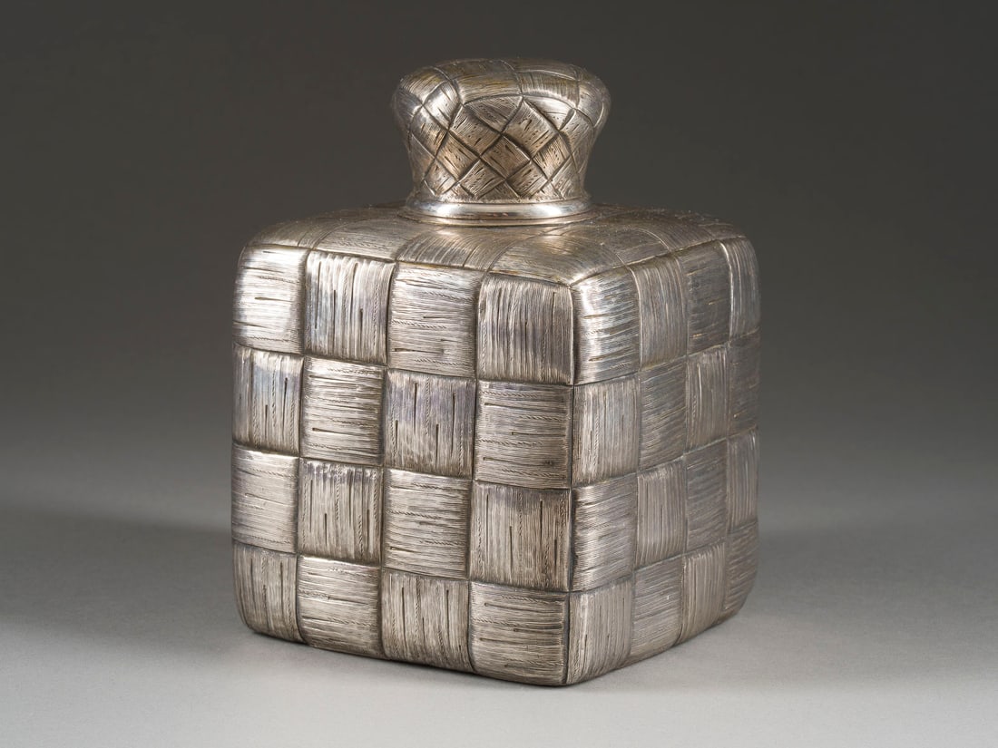 A SILVER TROMPE L'OEIL TEA CADDY: A SILVER TROMPE L'OEIL TEA CADDY Russian, St. Petersburg, late 19th century Square, the surface cast and engraved to simulate basketwoven birch, gilt interior. Marked with city hallmark, 84 standard a