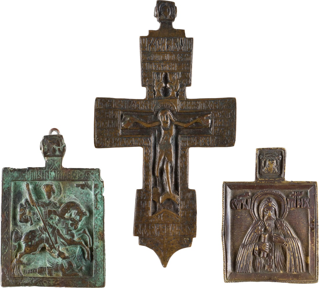 A COLLECTION OF THREE BRASS ICONS DEPICTING RARE CRUCIFIX, ST. TIKHON AND ST. GEORGE: A COLLECTION OF THREE BRASS ICONS DEPICTING RARE CRUCIFIX, ST. TIKHON AND ST. GEORGE KILLING THE DRAGON Russian, 17th/18th century Cast in relief, 6.6-13.1 cm high. SAMMLUNG VON DREI BRONZE-IKONEN: SE