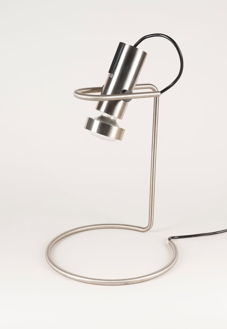 KNUD HOLSCHER - TISCHLEUCHTE 'STRINGLINE': KNUD HOLSCHER 1930 Rødby - 2025 Holte TISCHLEUCHTE 'STRINGLINE' Daenemark, Nordisk Solar, Entwurf 1977 Edelstahl, Kunststoff, 1-flg. elektrifiziert. H. 38,5 cm, B. 25 cm, T. 25 cm. Sehr leichte Gebra