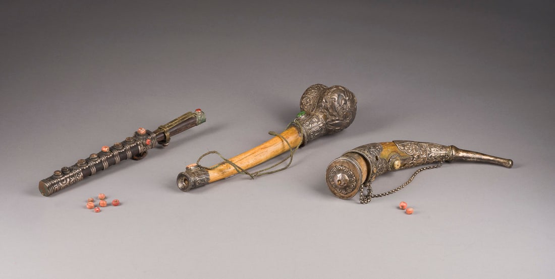DREI TIBETISCHE RITUELLE OBJEKTE: THREE TIBETAN RITUAL OBJECTS Tibet, 19th century Silver/bone/horn/coral etc.. L. ca. 30-32.5 cm. Including a kangling, a powder horn, and a travel set. With traces of age and use, partially damaged, w