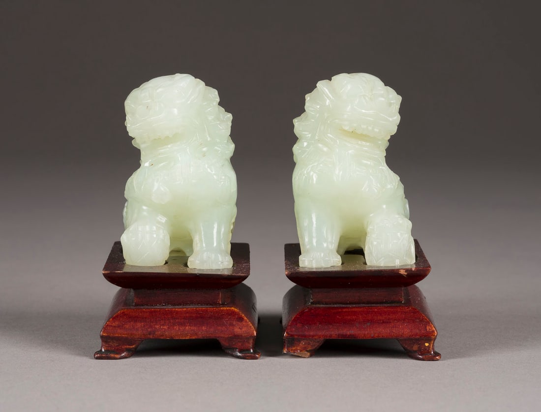 EIN PAAR BUDDHISTISCHE LOEWEN AUS HELLGRUENER JADE: A PAIR OF PALE GREEN JADE BUDDHIST LIONS China, 20th century Jade. H. ca. 8.4 cm with base. With traces of age.EIN PAAR BUDDHISTISCHE LOEWEN AUS HELLGRUENER JADE China, 20. Jahrhundert Jade. H. ca. 8,
