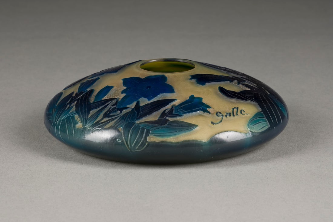 EMILE GALLE | KREISELVASE 'BLAUE TROMPETENWINDE': EMILE GALLE 1846 Nancy - 1904 ebenda KREISELVASE 'BLAUE TROMPETENWINDE' Frankreich, Nancy, 1906-1914 Farbloses Glas, gelber Unterfang, blauer Überfang, Ätzdekor. D. 16 cm. Auf Wandung bez. 'Galle' (