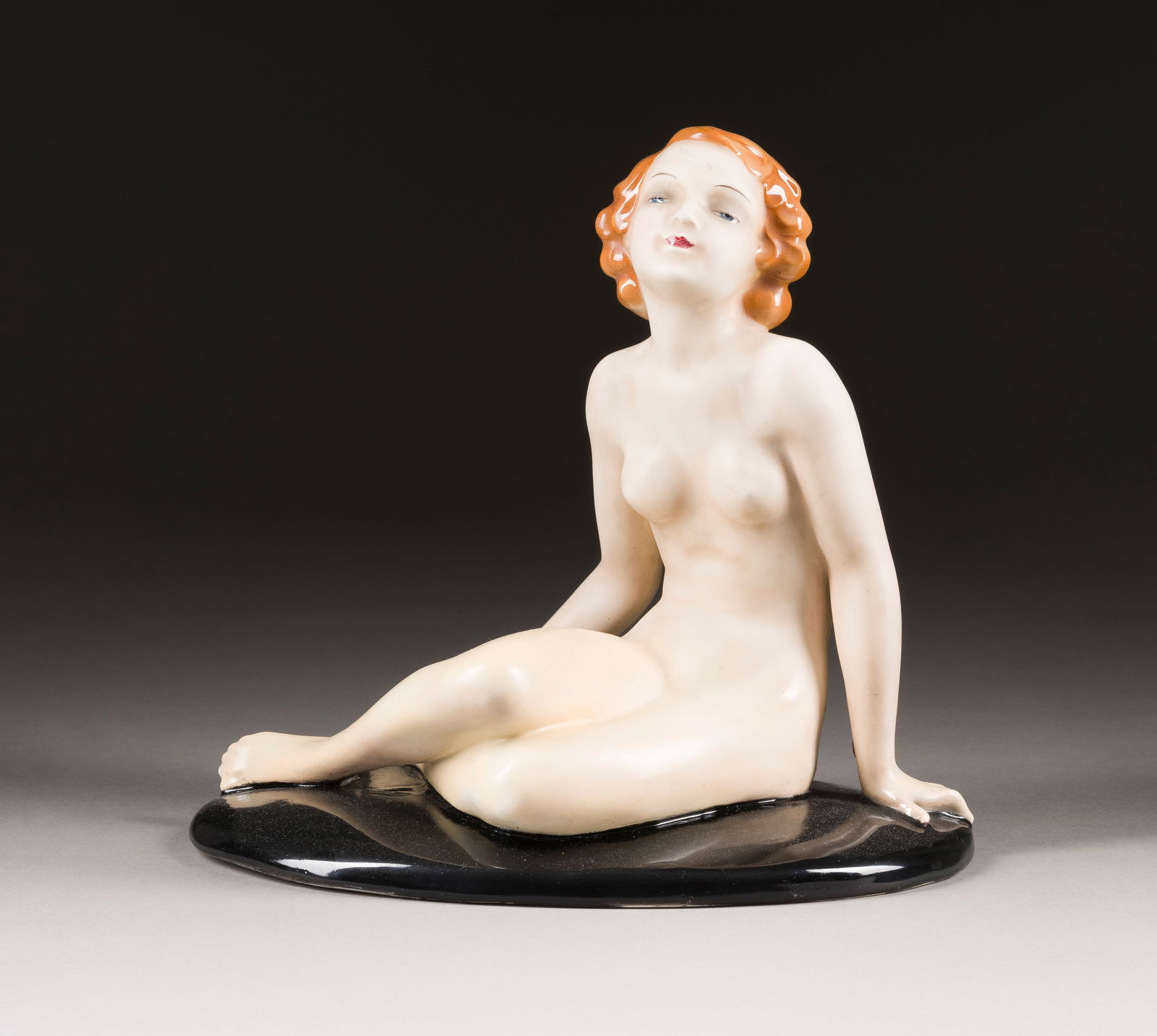 | SITZENDER FRAUENAKT: SITZENDER FRAUENAKT Österreich, Wien, Friedrich Goldscheider, um 1950 Steingut, polychrom glasiert. H. 25 cm. Firmenstempel (in schwarz), 'MADE IN GERMANY', Modellnr. '8426 25 6' (eingepresst).SITZEN