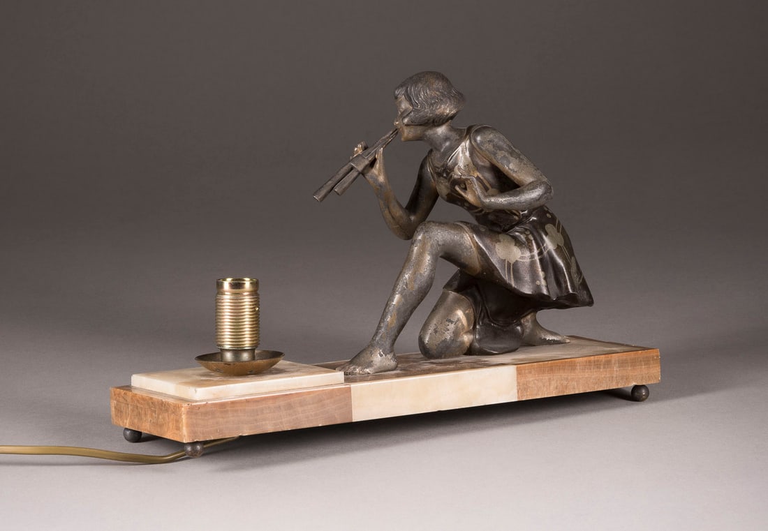 GEORGE MAXIM | ART-DECO-TISCHLAMPE 'FLÖTESPIELERIN': GEORGE MAXIM 1895 - 1940 ART-DECO-TISCHLAMPE 'FLÖTESPIELERIN' Frankreich, 1. Hälfte 20. Jh. Regule, part. patiniert, Marmor, elektrifiziert (Funktion nicht geprüft). L. 33,5 cm, H. 23,5 cm. Bez.