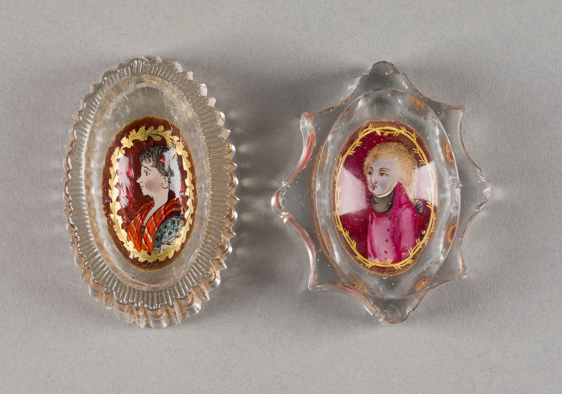 | PAAR SALIEREN MIT PORTRÄT: PAAR SALIEREN MIT PORTRÄT Böhmen, 18. Jh. Farbloses Glas, polychrome Malerei, dezente Goldstaffage. L. 7,9-8,5 cm. Part. best.PAAR SALIEREN MIT PORTRÄT