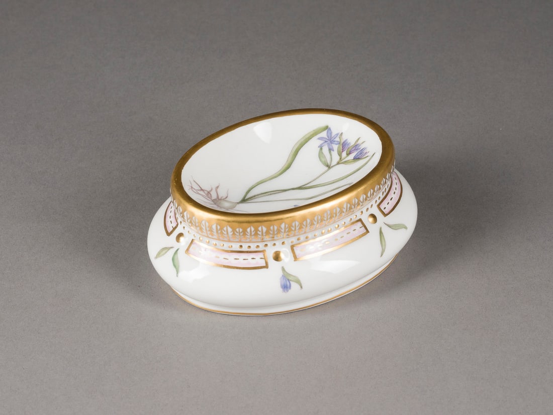 | SALZGEFÄSS 'FLORA DANICA': SALZGEFÄSS 'FLORA DANICA' Dänemark, Royal Copenhagen, 1975-1979 Porzellan, polychrome Malerei, Goldstaffage. L. 11 cm, H. 4 cm. Grüne Manufakturmarke, blaue Wellenmarke, Malerzeichen, Modellnr.