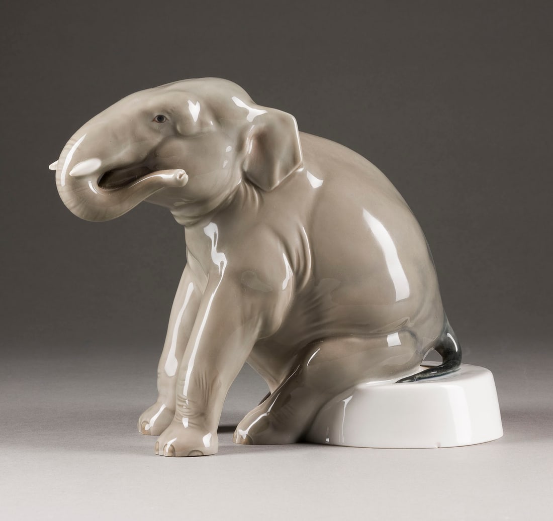 RUDOLF LÖHNER | ELEFANT AUF PODEST: RUDOLF LÖHNER 1890 Zuckmantel/ Mähren - 1971 Dresden ELEFANT AUF PODEST Deutsch, Meissen, 1950 (Entwurf 1913) Porzellan, Unterglasurdekor in Grau. H. 19 cm. Unterglasurblaue Schwertermarke,