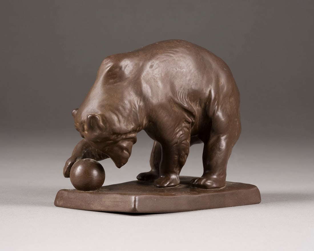 JOSEF FRANZ PALLENBERG | SPIELENDER BÄR MIT KUGEL: JOSEF FRANZ PALLENBERG 1882 Köln - 1946 Düsseldorf SPIELENDER BÄR MIT KUGEL Deutsch, Goebel, ab 1935 Steinzeug, part. poliert. H. 11 cm. Manufakturmarken, 'C.W. 7'. Auf Plinte bez. 'Jos.
