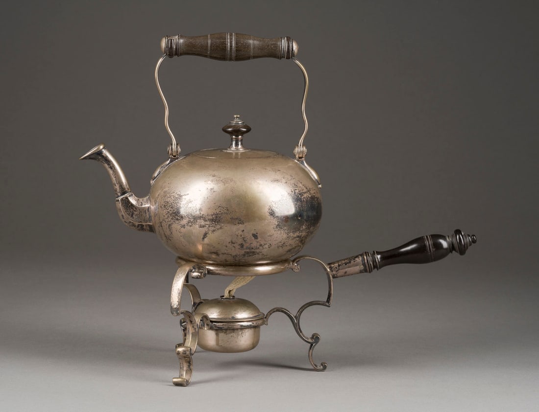 | TEEKANNE AUF STÖVCHEN: TEEKANNE AUF STÖVCHEN Deutsch, Schleswig, Lorenz Hinrich Severin (1729 - 1791) Silber, Holz. Gesamt-H. ca. 28,8 cm, 1260 g. Die Kanne unterseitig punziert mit Beschau- u. Meistermarke. Die Kanne min.