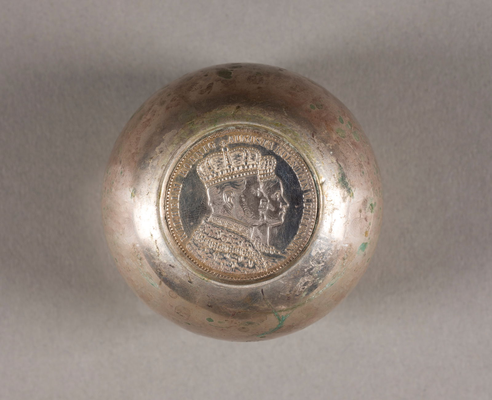 | BECHER MIT KRÖNUNGSTALER: BECHER MIT KRÖNUNGSTALER Deutsch, ab 1888 800er Silber. Gew. 104 g, H. 5,7 cm. Punziert mit Halbmond, Krone, Feingehalt '800'. Preußen-Krönungstaler 1861 Wilhelm I., SS. Monogrammiert mit 'BW'.