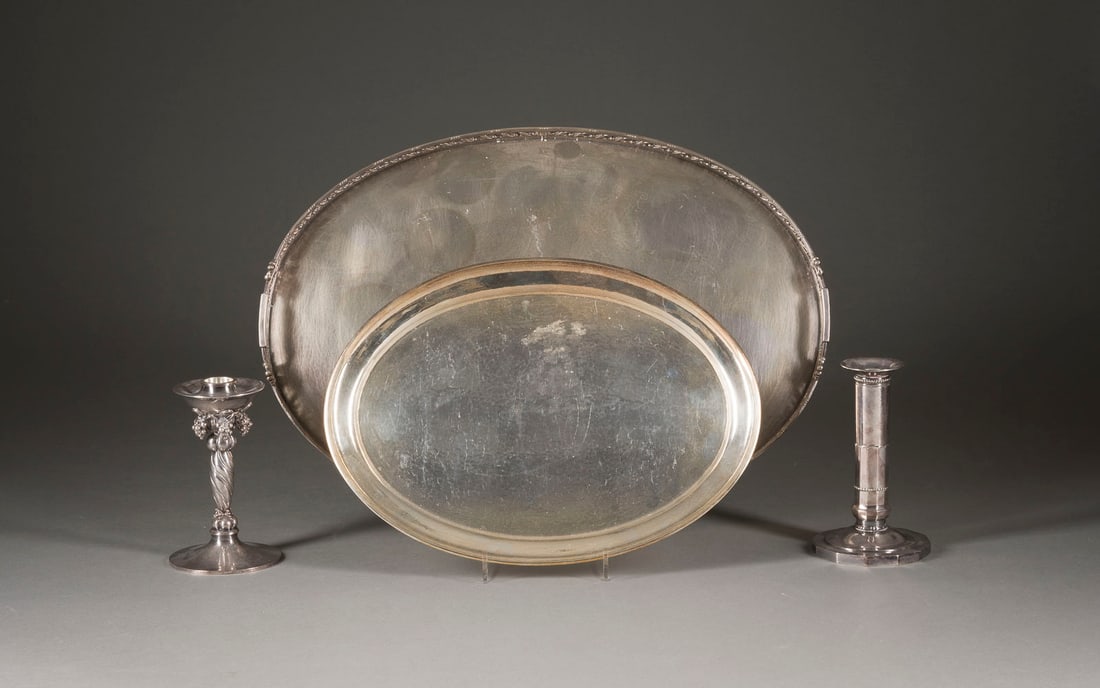 | ZWEI KERZENHALTER UND ZWEI TABLETTS: ZWEI KERZENHALTER UND ZWEI TABLETTS Dänemark, Georg Jensen, Johan Rohde, nach 1945 Sterlingsilber. Ges.-Gew. 3421 g, H. 14,5-15,5 cm (Kerzenhalter). Punziert mit Herstellermarke 'Georg Jensen', u.a.