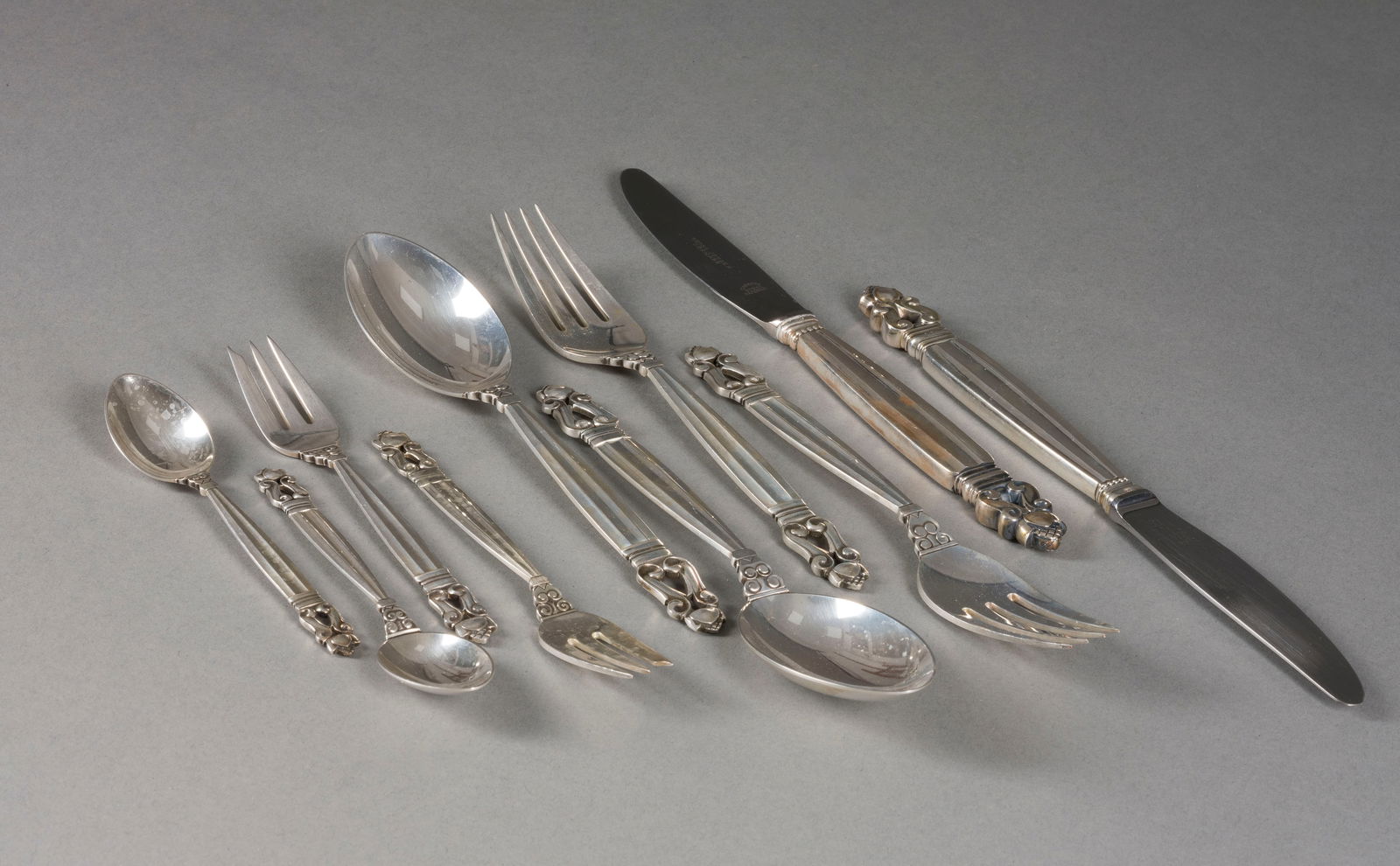 | 60-TEILIGES BESTECK 'ACORN': 60-TEILIGES BESTECK 'ACORN' Dänemark, Kopenhagen, Georg Jensen, Entwurf: Johan Rohde 1915, Ausführung: nach 1945 Sterlingsilber, Metall. Ges.-Gew. 2040 g (ohne Messer), L. 12,5-22,5 cm. Jew.