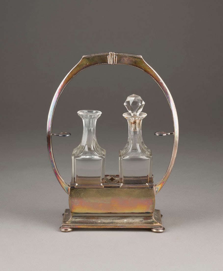 | ESSIG/ÖL-MENAGE: ESSIG/ÖL-MENAGE Wohl Deutsch, 20. Jh. 800er Silber. H. 24,5 cm, 197 g (Silber). Punziert mit Feingehaltsangabe '800' und Herstellermarken. Verschluss einer Flasche fehlt.ESSIG/ÖL-MENAGE