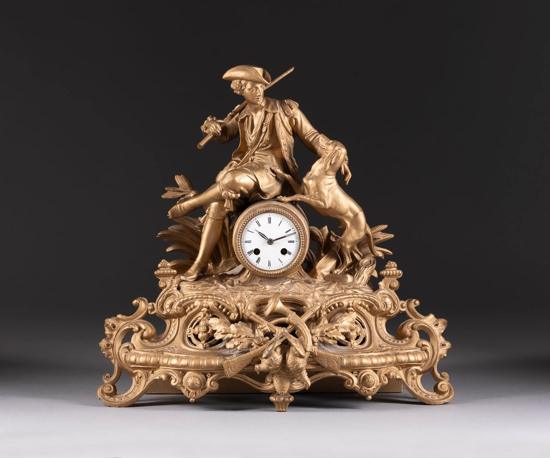 | TISCHUHR 'JÄGER MIT HUND': TISCHUHR 'JÄGER MIT HUND' Frankreich, LEP Japy & Cie, um 1860 Metallguss, goldfarben gefasst, Email, Metall, Stahl. 45 x 48 x 20 cm. Auf dem Werk bez. ' LEP Japy & Cie' und Nr. '9032'. Reich verziert