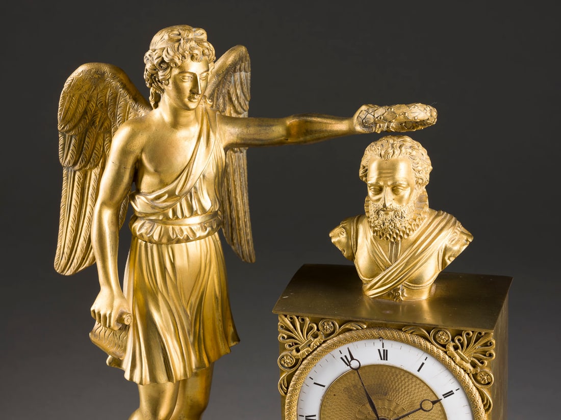 | EMPIRE PRUNKPENDULE MIT GENIUS DES RUHMES: EMPIRE PRUNKPENDULE MIT GENIUS DES RUHMES Frankreich, Paris, Francois-Joseph Hartmann, um 1820/30 Bronze, vergoldet, Email, Metall, Stahl. 45 x 32 x 15,5 cm. Auf dem Ziffernring bez. 'Hartmann à