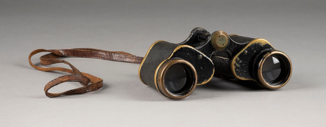 | FERNGLAS MIT FADENKREUZ: FERNGLAS MIT FADENKREUZ 20. Jh. Metall, geschwärzt, part. ummantelt, Glas, Lederriemen. 6 x 15 cm. Ohne Herstellermarke, undeutl. Modellnr. '6...30'. Starke Gebrauchsspuren.FERNGLAS MIT FADENKREUZ
