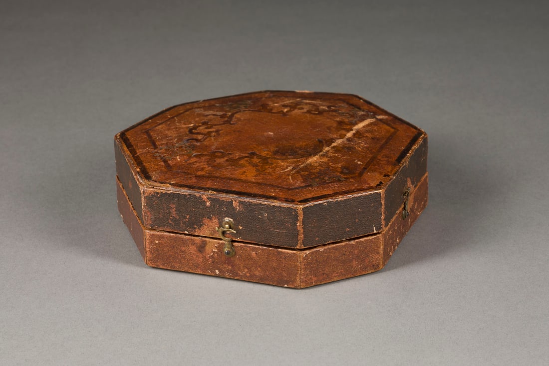 | ÄQUATORIAL-KOMPASS: ÄQUATORIAL-KOMPASS Frankreich, 19. Jh. Messing, Glas, Stahl, in mit geprägtem Leder bezogener Holzschatulle. 5 x 14,5 x 15,5 cm. Mit zwei Wasserwagen versehener, höhenverstellbarer Kompass.