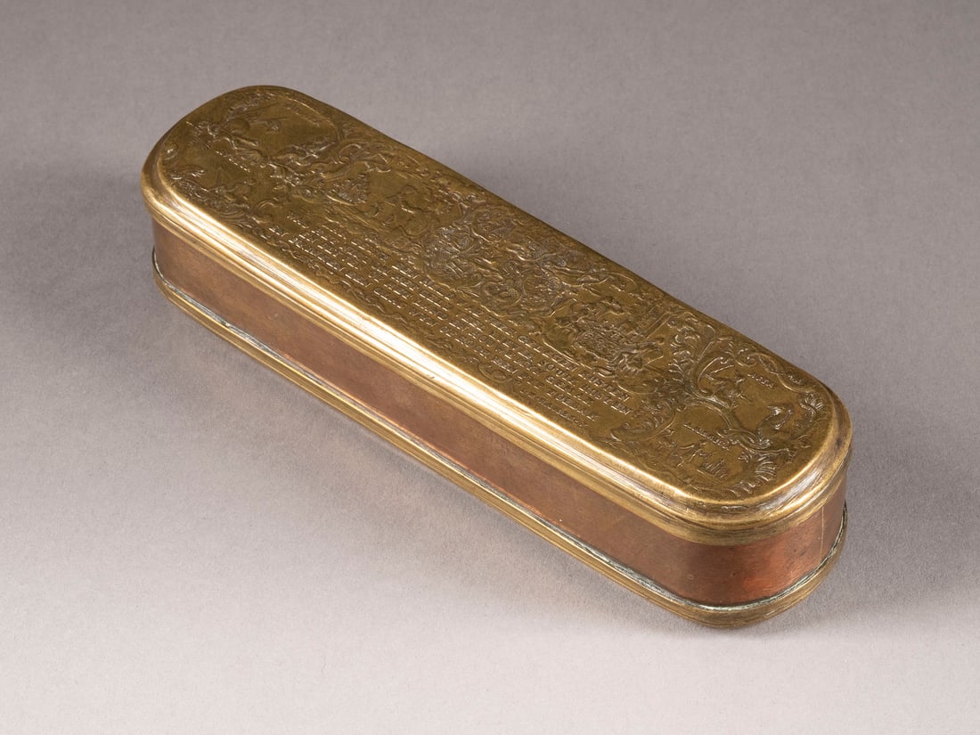 | ISERLOHNER TABAKSDOSE: ISERLOHNER TABAKSDOSE Deutsch, Johann Heinrich Hamer, um 1760 Messing, Kupfer. 15,5 x 4,5 x 3,5 cm. Bez. 'I. H. Hamer f.'. Längsrechteckige Form mit abgerundeten Enden und scharniertem Deckel. Messin