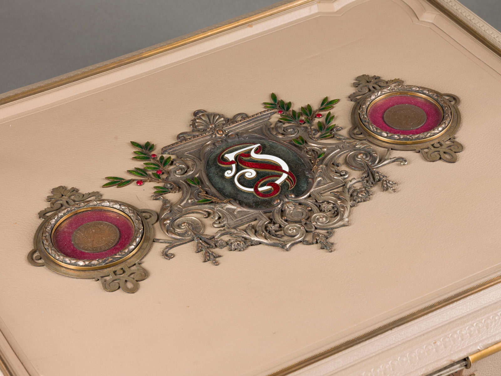 | DOKUMENTENKASSETTE: DOKUMENTENKASSETTE Ungarn, Budapest, Anfg. 20. Jh. Bronze, part. vergoldet, Metall, Email, Samt, Textil. 16 x 53 x 43 cm. Innen bez. 'Czettel es Deutsch Budapest'. Auf vier blattverzierten