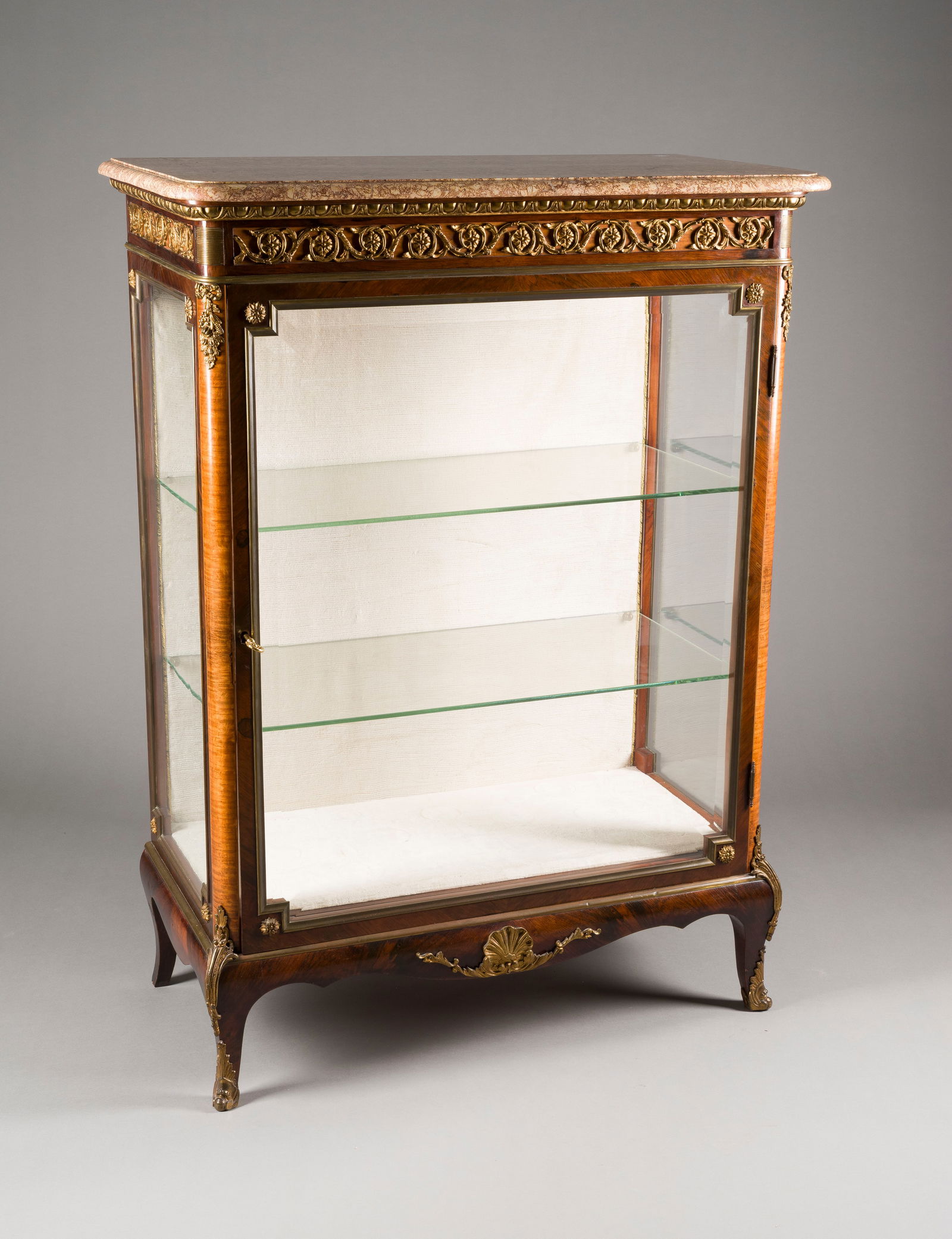 | LOUIS XV VITRINE: LOUIS XV VITRINE Frankreich, zweite Hälfte 19. Jh. Rosenholz, furniert, reich mit vergoldeten Appliken, verglaste Tür und Seiten, zwei Glasböden, Marmorplatte, Schlüssel. In der Art von François
