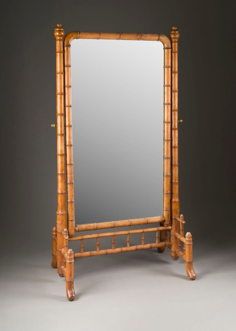 | GROSSER STANDSPIEGEL: GROSSER STANDSPIEGEL Wohl Frankreich, um 1880 Bambus, Spiegelglas, Messingappliken. H. 164, B. 84, T. 52. Auf einem durchbrochenen Stand mit von zwei Säulen gehaltenem, gerundeten Rahmen. Glas part.