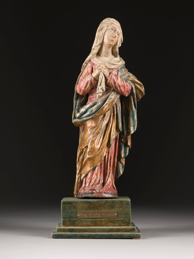 | TRAUENDER MARIA: TRAUENDER MARIA Wohl Fulda, 16. Jh. Lindenholz, plastisch geschnitzt, vergoldet, polychrom gefasst, rückseitig geflacht, mit Sockel (H. 7 cm). Figur H. 34, B. 14, T. 8 cm. Am Sockel bezeichnet 'Madon