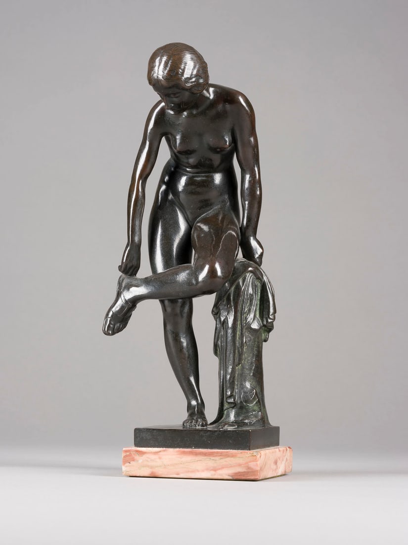 HUGO KAUFMANN | APHRODITE / VENUS SICH DIE SANDALE AUSZIEHE: HUGO KAUFMANN 1868 Schotten - 1919 München APHRODITE / VENUS SICH DIE SANDALE AUSZIEHEND Bronze, dunkel patiniert, auf quadratischer Plinthe und Marmorsockel. Ges.-H. 33, B. 13, T. 10,5 cm, Gew. ca.