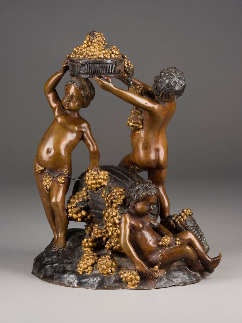 AUGUSTE MOREAU | BACCHANTENSZENE MIT WEINFASS UND TRAUBEN: AUGUSTE MOREAU 1861 Dijon - 1906 Paris (nach) BACCHANTENSZENE MIT WEINFASS UND TRAUBEN Bronze, vergoldet, braun und dunkel patiniert. H. 30,5, B. 25, T. 25 cm, Gew. ca. 6,85kg. Part. best. und Verlust