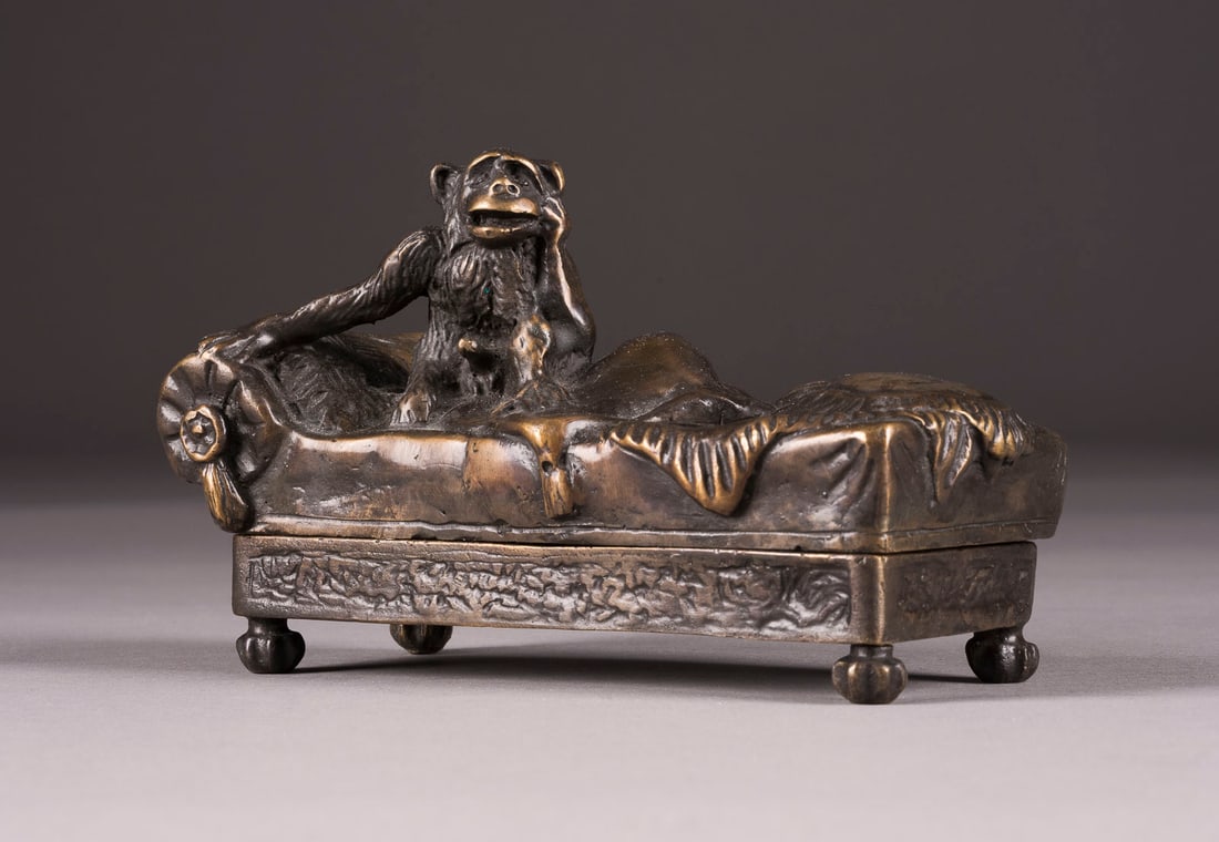 FRANZ XAVER BERGMANN | AFFE AUF EINEM CANAPE SITZEND (EROTI: FRANZ XAVER BERGMANN 1861 Österreich - 1936 AFFE AUF EINEM CANAPE SITZEND (EROTIKA FIGUR) Wiener Bronze, dunkel patiniert,. H. 7,5, B. 14, T. 6,5 cm, Gew. ca. 0,59kg. Rückseitig Krugmarke 'B', Verso